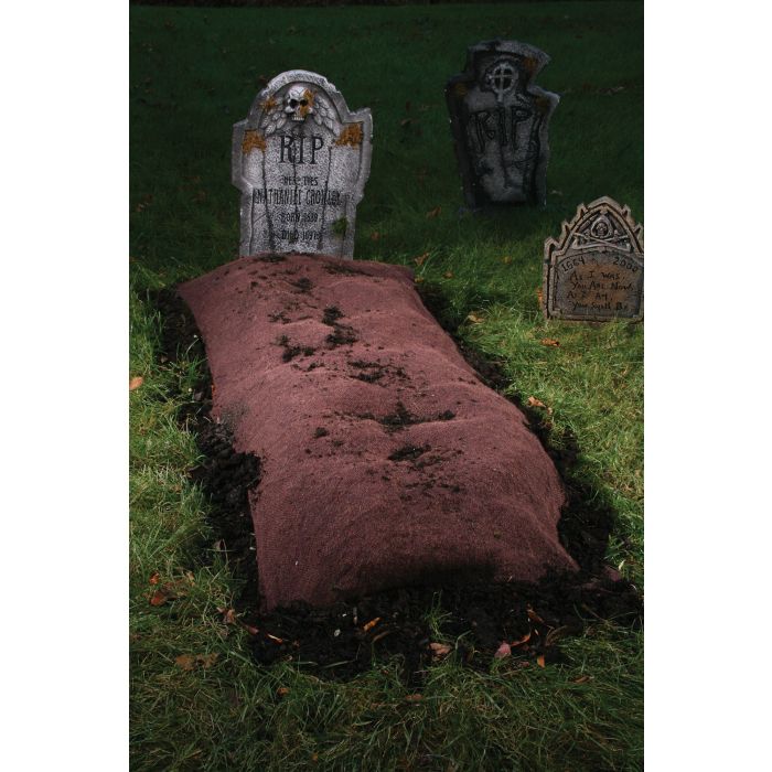 A grave mound with stakes designed for Halloween party decoration, placed over a burlap blanket on the grass.