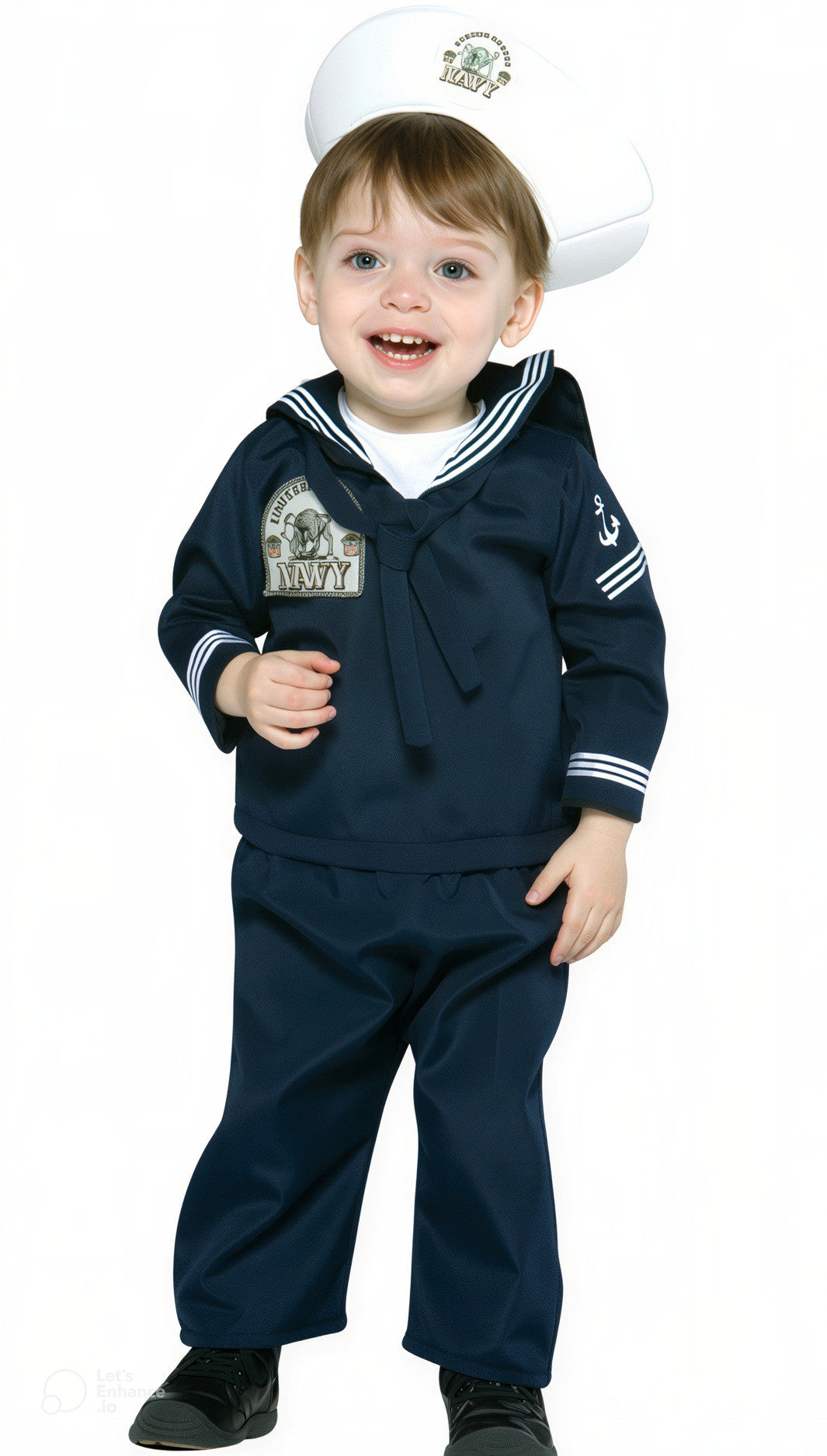 A toddler wearing a navy blue sailor costume set with a white hat.